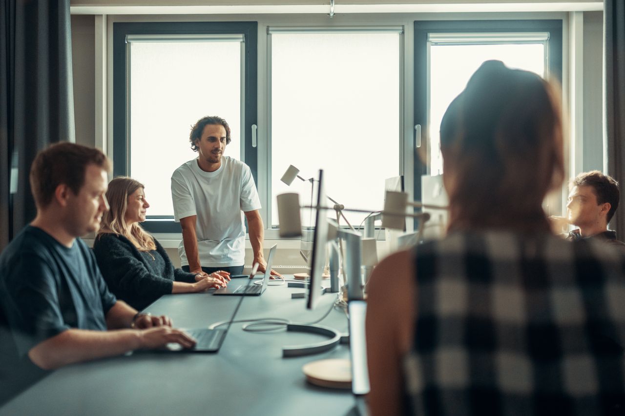 A diverse team taking part in a discussion during a collaborative office meeting.